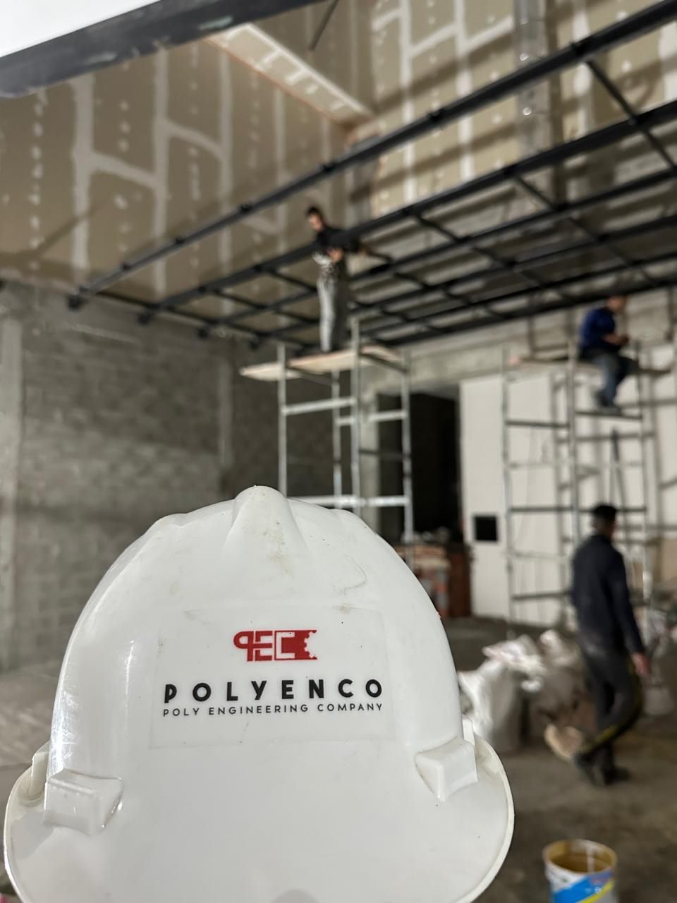 POLYENCO - Casque de chantier POLYENCO, équipe au travail en arrière-plan