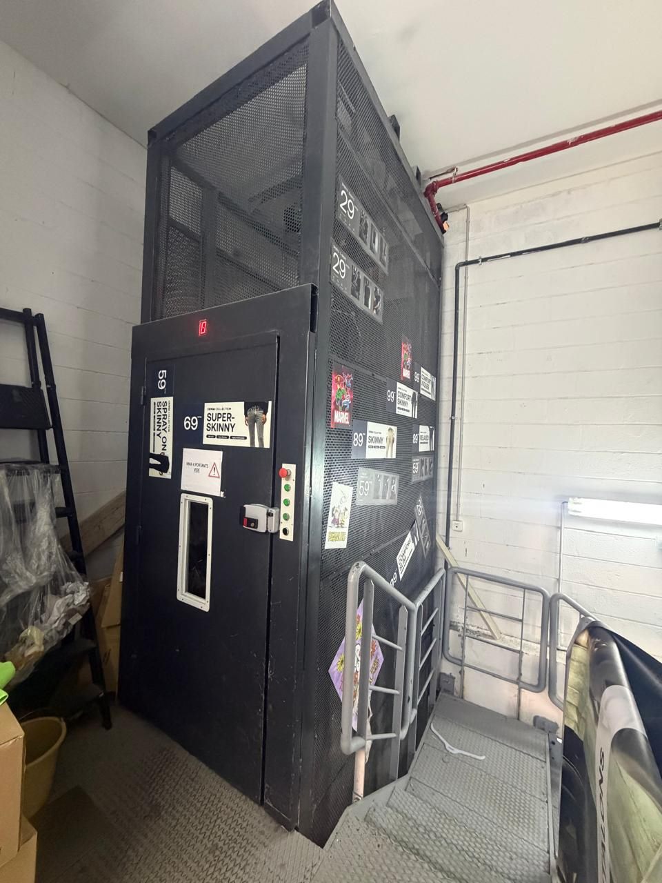 POLYENCO - Monte-charge à cage métallique et porte palière dans une réserve